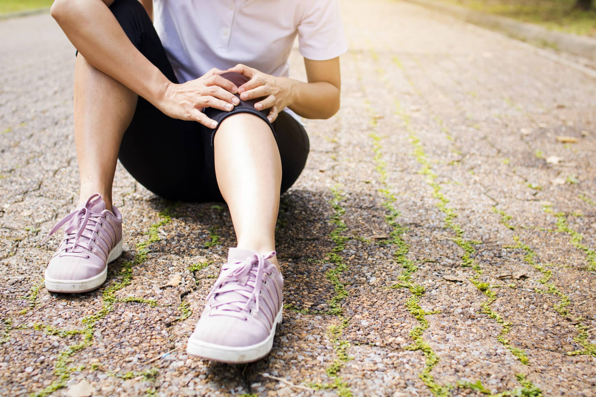 woman suffering pain from distal quad tendinopathy scaled - Distal Quad Tendinopathy