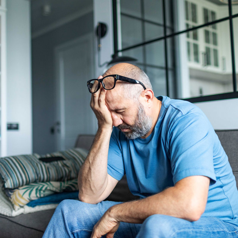 man with low energy sitting on his couch