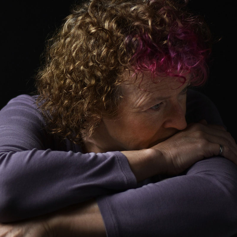 woman with low self-esteem holding her head on her arms