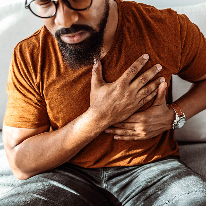 man holding his chest with cardiovascular issues